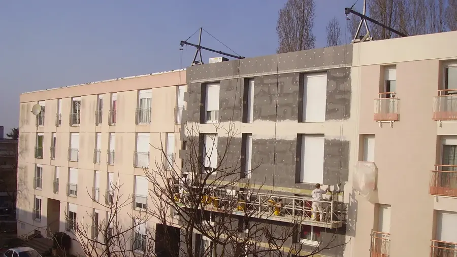 EIFS foam insulation board and basecoat being applied over an existing building facade