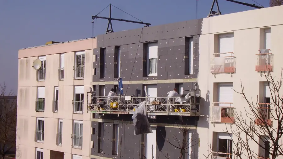 EPS foam insulation boards fastened to a building facade before basecoat and mesh are applied, the layer that makes EIFS cost more than traditional stucco