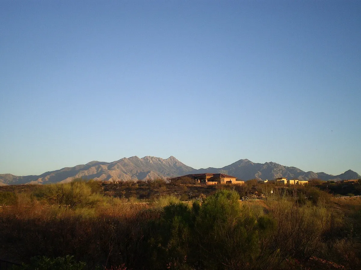 Desert scrub and homes in Green Valley at dusk with the Santa Rita Mountains behind