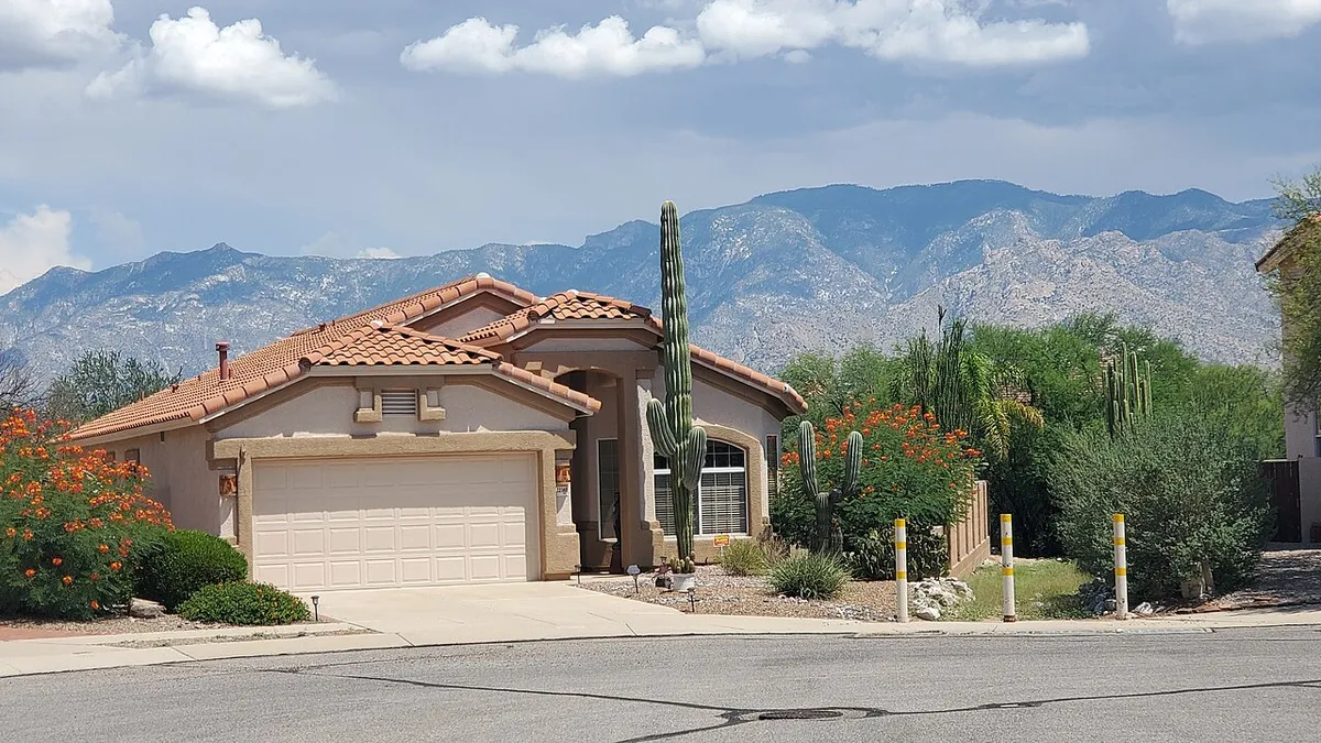 A stucco house with a tile roof and desert landscaping, Santa Catalina Mountains behind, Oro Valley