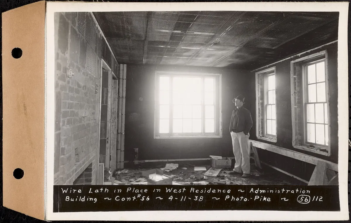 1938 photo of wire lath fastened over the walls of a room before plastering